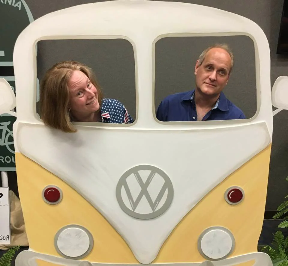 Family posing inside a vintage van cutout.