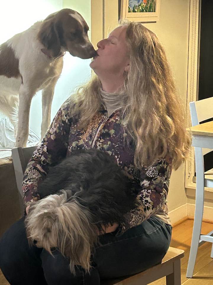 Woman with two dogs indoors.